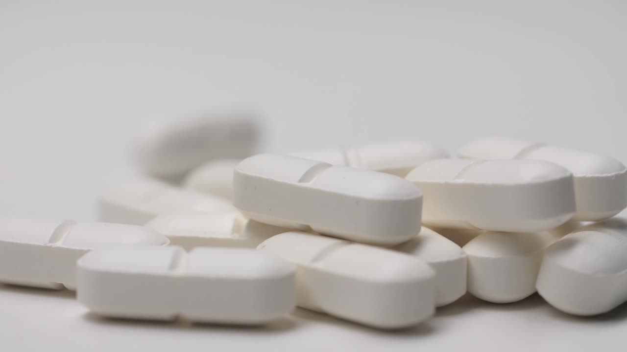 슬로우 모션으로 흰색 배경에 미끄러지는 흰색 알약