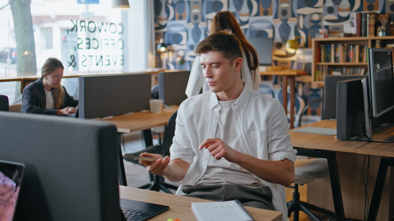 Sales professional speaking mobile phone with client at contemporary workplace