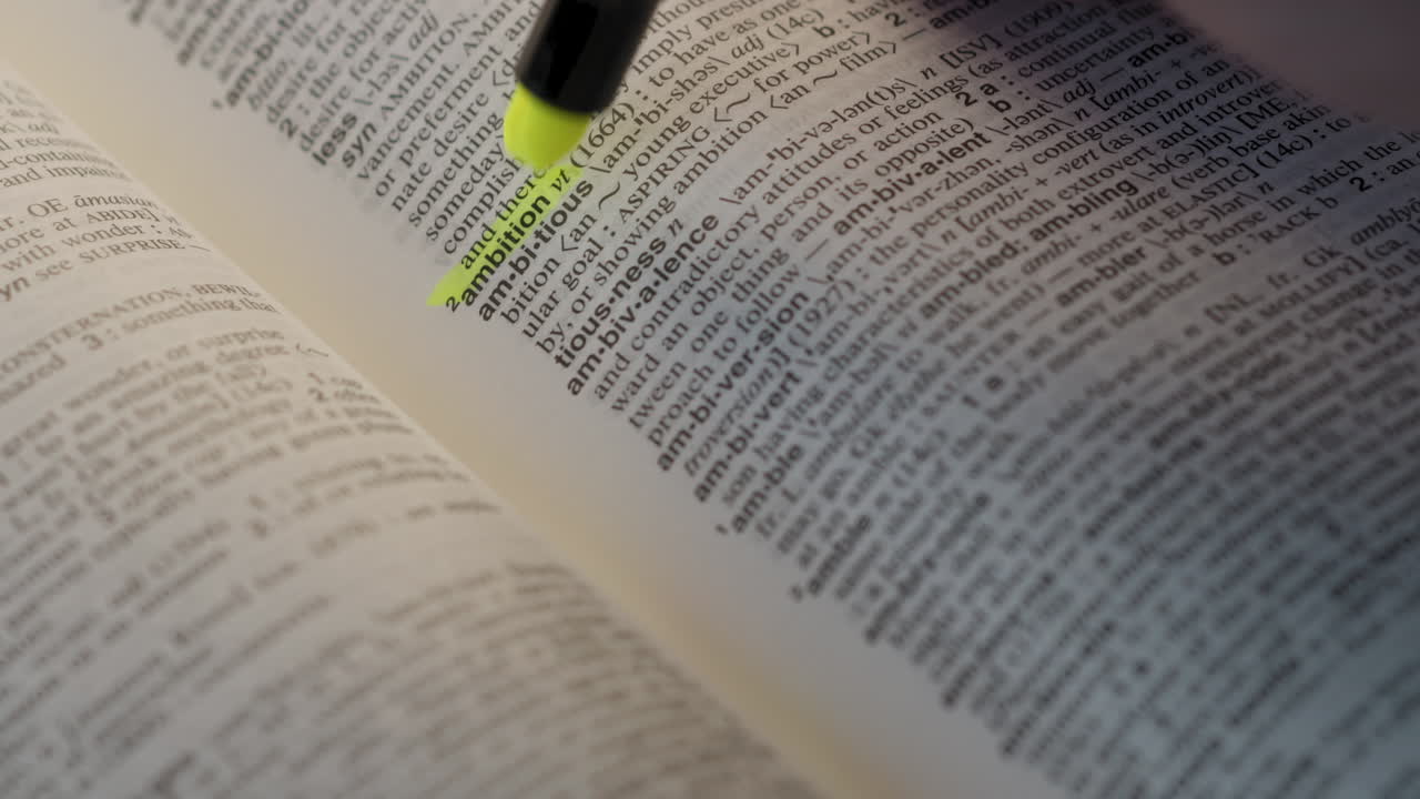 Ambition Business Dictionary Highlighter Concept, highlighting a word in a dictionary to show it's definition