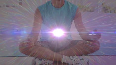 animation of caucasian man practicing yoga meditating with white light flickering in the foreground