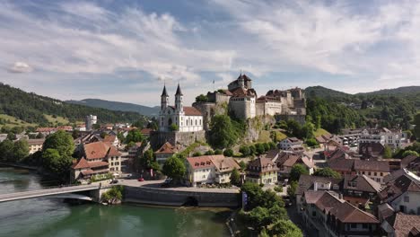 aarburg castle and church on rocky hill beside aare river in switzerland, stunning drone aerial view