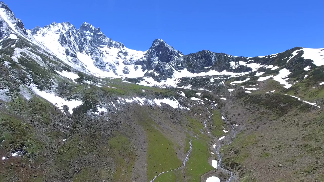 Vista aerea di un ruscello di montagna che scorre attraverso una valle verde