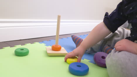 baby boy playing with colorful stacking rings