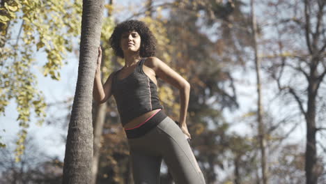 workout routine stretches in the woods by a ebony model