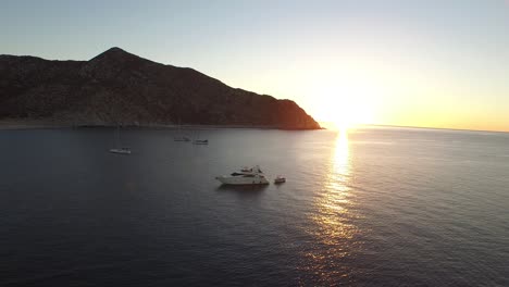 Toma-Aérea-De-Un-Kayak-Y-Botes-Al-Amanecer,-Parque-Nacional-Cabo-Pulmo,-Baja-California-Sur