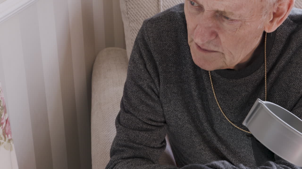 Elderly man with crutch indoors