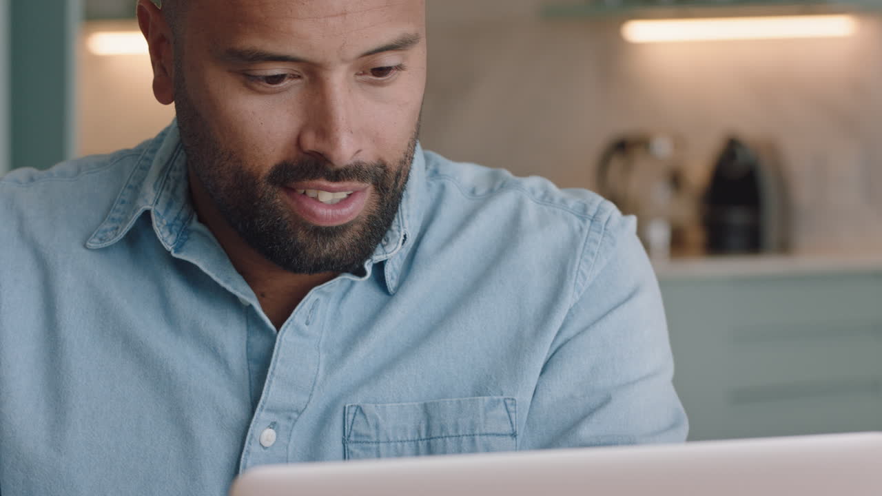 hombre atractivo que usa una computadora portátil trabajando en casa navegando en línea leyendo mensajes de correo electrónico en la computadora mirando un reloj de muñeca disfrutando de la comunicación digital