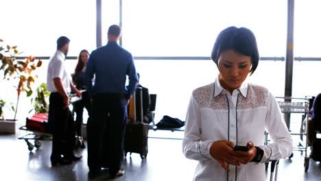 woman using mobile phone while commuters interacting with each other