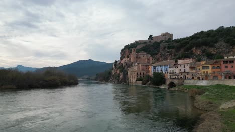 Charmantes-Am-Flussufer-Gelegenes-Städtchen-Miravet,-Spanien-Mit-Bunten-Häusern-Und-Einer-Burg-Auf-Einem-Hügel