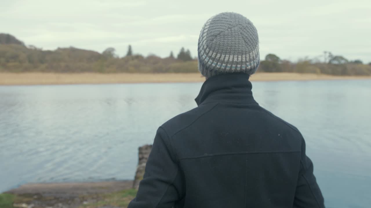 강변 에 정박 한 로우 보트 로  ⁇ 고 있는 사람