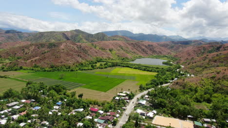 aerial view of green rice field and mountain with clear sky during daytime in 4k quality