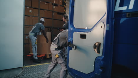 logistics team loading and unloading boxes from a delivery truck at a warehouse