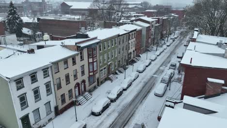 snowy street with snow covered cars in suburbia of american city