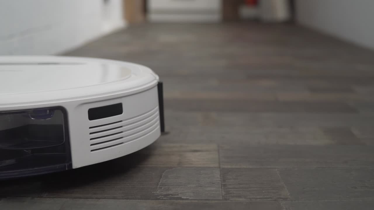 robot aspirador automático, máquina de piso limpio. robot aspirador limpieza automática en el hogar. aspirador robot realiza la limpieza automatizada del apartamento en un momento determinado. hogar inteligente
