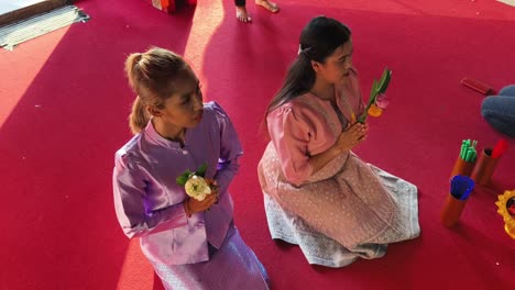 women praying at a buddhist temple in thailand