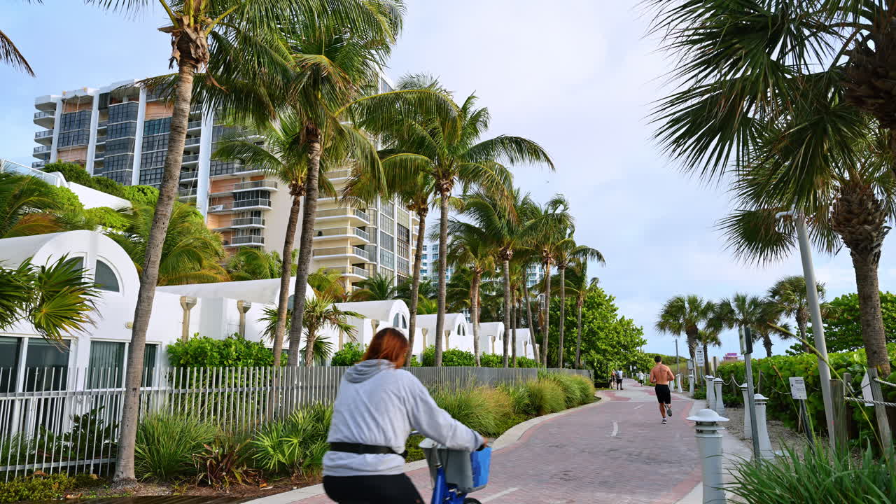 Miami, USA, 9 aprile 2026: Un jogger sul percorso di South Pointe Park con palme. Un uomo corre su una passeggiata pavimentata costeggiata da palme e architettura moderna a South Pointe Park, Miami.