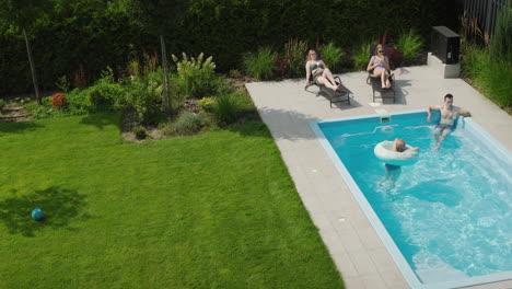 happy family relaxing by the pool on a hot summer day