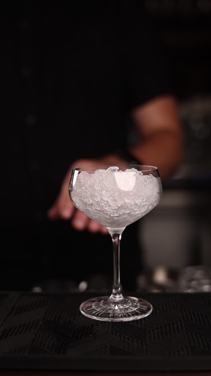 Un barista che prepara un cocktail con ghiaccio