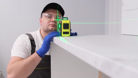 checking the quality of furniture using a modern electronic level checking the quality of furniture using a modern electronic level a professional craftsman checks the quality of furniture installation