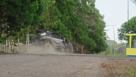 dirt buggy skidding onto road and driving off into the horizon in punta cana in dominican republic. slow motion, tracking shot