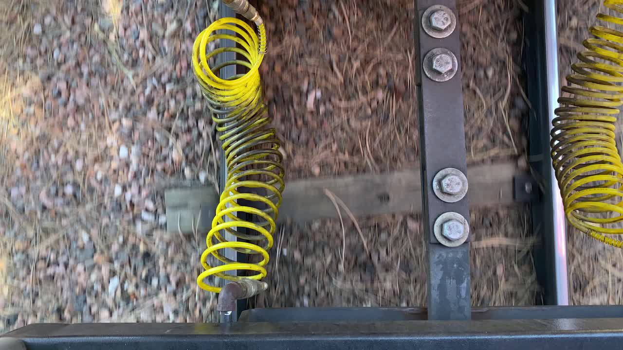 вид сверху на соединение железнодорожного вагона между двумя вагонами поезда, крупным планом