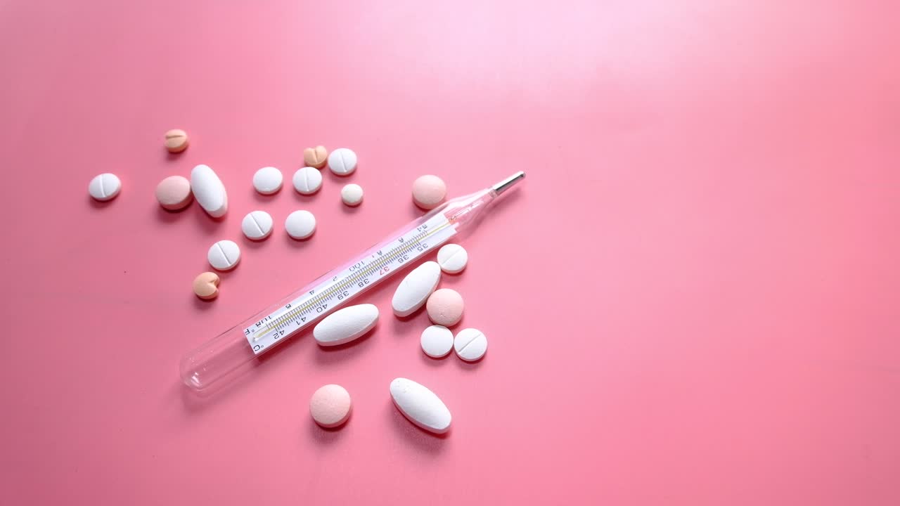 핑크색 바탕에 의료 용품과 온도계