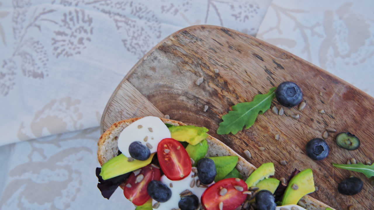 Delicious, healthy, avocado, mozzarella and tomato baguette recipe on a bread board for a perfect picnic meal when on diet - top view