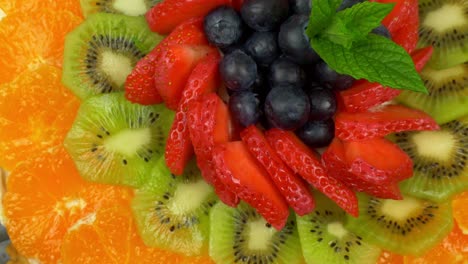 rotating shot of a fruit tart with the circular laying of colourful fruits