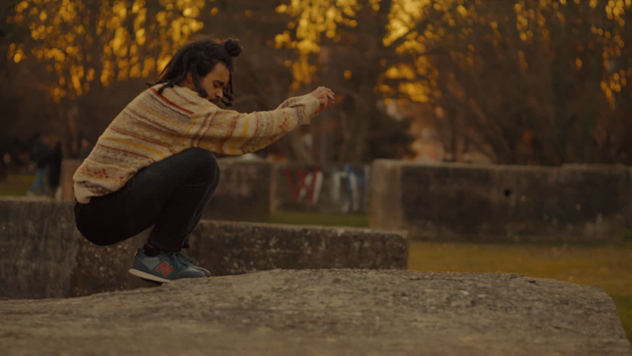 Man Jumping and Posing in Park at Sunset