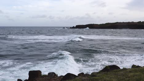 The-ocean-waves-breaking-on-the-rocks-along-the-seashore-casting-spray-into-the-air