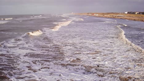 gente nadando y disfrutando de su tiempo en la playa en katwijk aan zee, al sur de holanda - toma aérea