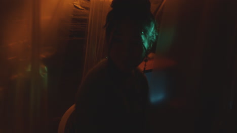 young asian woman in dark studio with neon illumination and retro tv