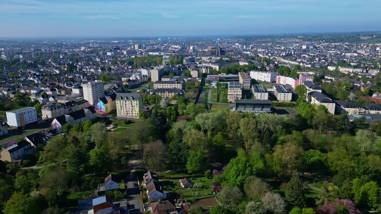 Upward panorama drone movement of the popular Parc de Banjan urban park on Les Maillets district with the Cathedral of Saint Julian of Le Mans in background, France.
