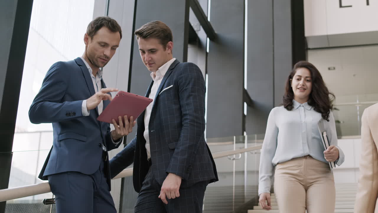 два коллеги используют планшет в офисном центре