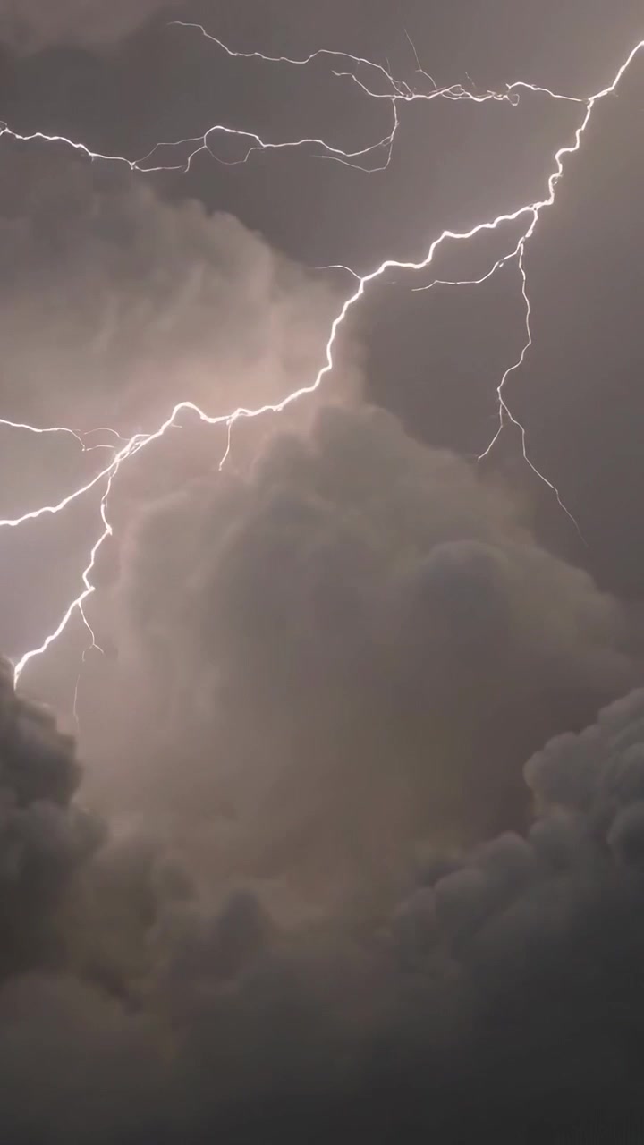 Video verticale: Fulmine a saetta che si dirama, cumulonembo che scintilla e bagliore delle nuvole che pulsa e si illumina di notte.