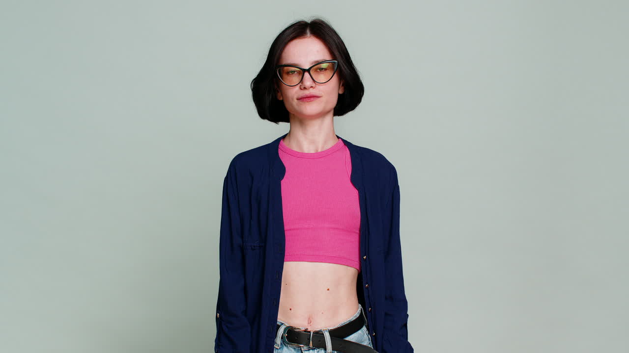 Woman making heart shape with fingers looking gently at camera expressing love affection caring