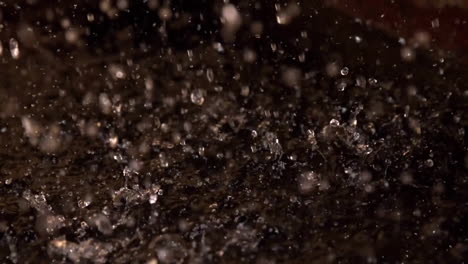 raindrops splashing on dark surface, creating ripples and droplets in animation