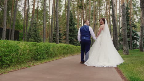 the bride and groom are walking in the park steadicam shot