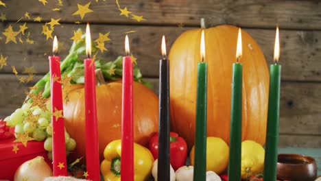 animation of golden stars over kwanzaa candles and pumpkins