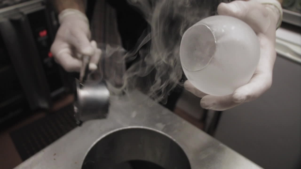 A chef cutting a hole in an isomalt sugar sphere for dessert | Premium ...
