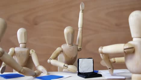 wooden figurines having meeting in conference room in office on wooden background