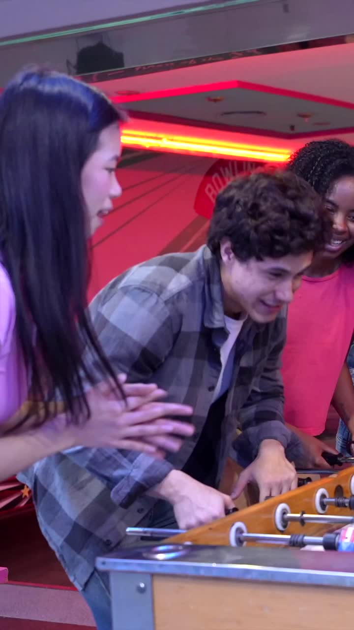 Group of friends playing foosball and celebrating