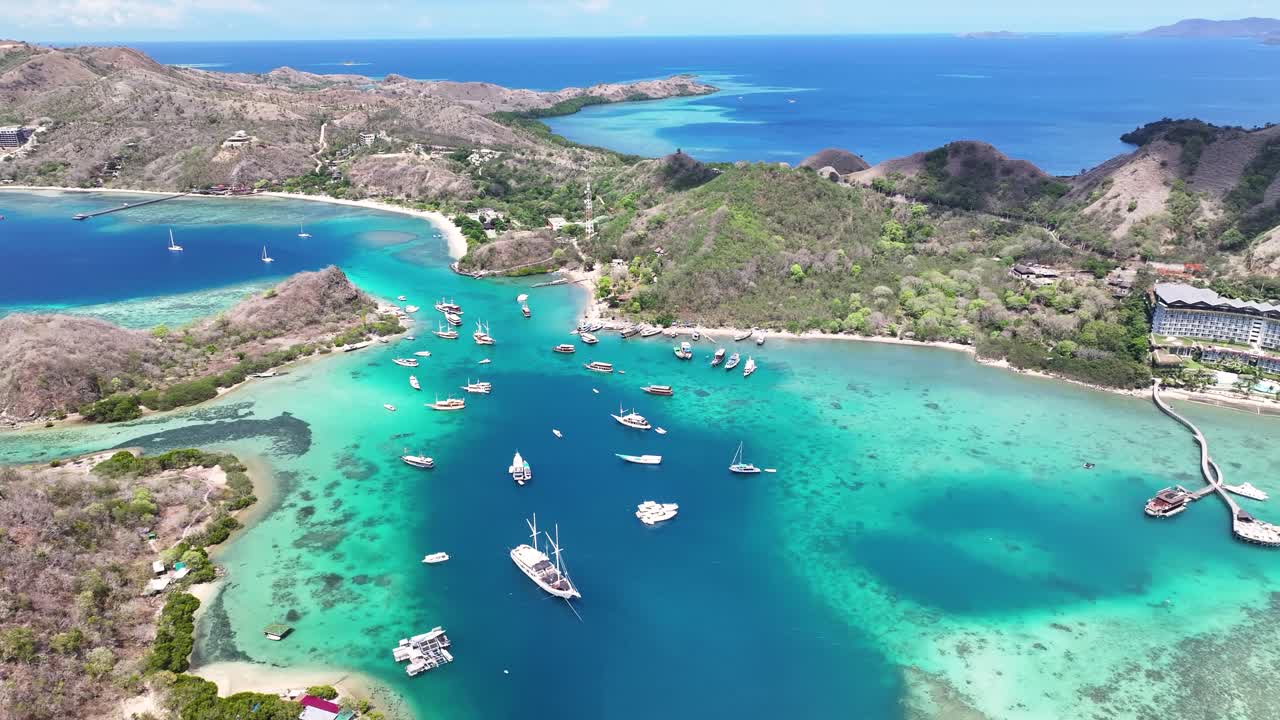 Crystal clear waters at Flores with boats. Aerial coastal landscape, Labuan Bajo, Indonesia