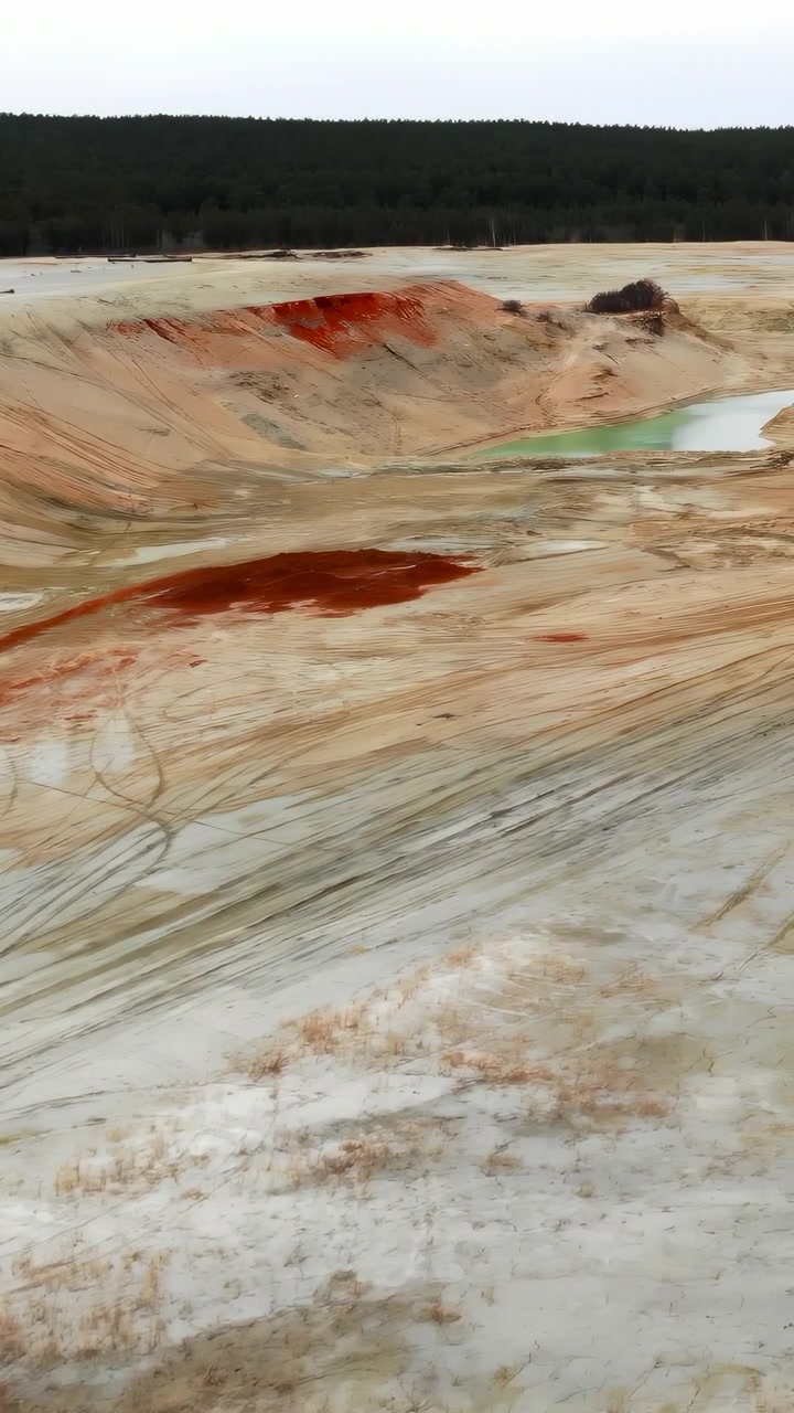 Aerial View Desolate Sand Pit Landscape With Pale Clay And Scrubby Ridges Under Overcast Sky, Slow Drone