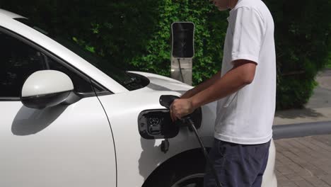 el hombre instaló el cable progresivo en su coche ev desde la estación de carga de su casa.