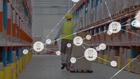 animation of network of icons over rear view of caucasian male worker pulling a pallet at warehouse