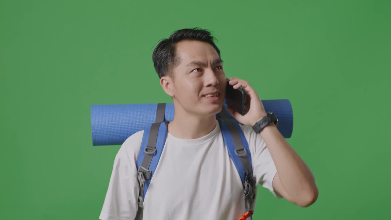 초록색 화면에 있는 남자가 배과 요가 매트와 함께 전화로 이야기하고 있다.