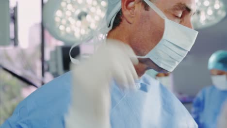 primer plano de un médico caucásico que lleva una máscara quirúrgica en la sala de operaciones del hospital