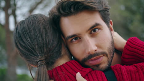 closeup man hugging woman on nature. happy guy embracing lovely girl outdoors.