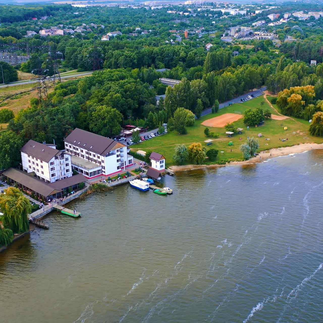 Beautiful landscape of the city on the river bank. Urban area with exuberant greenery from aerial perspective